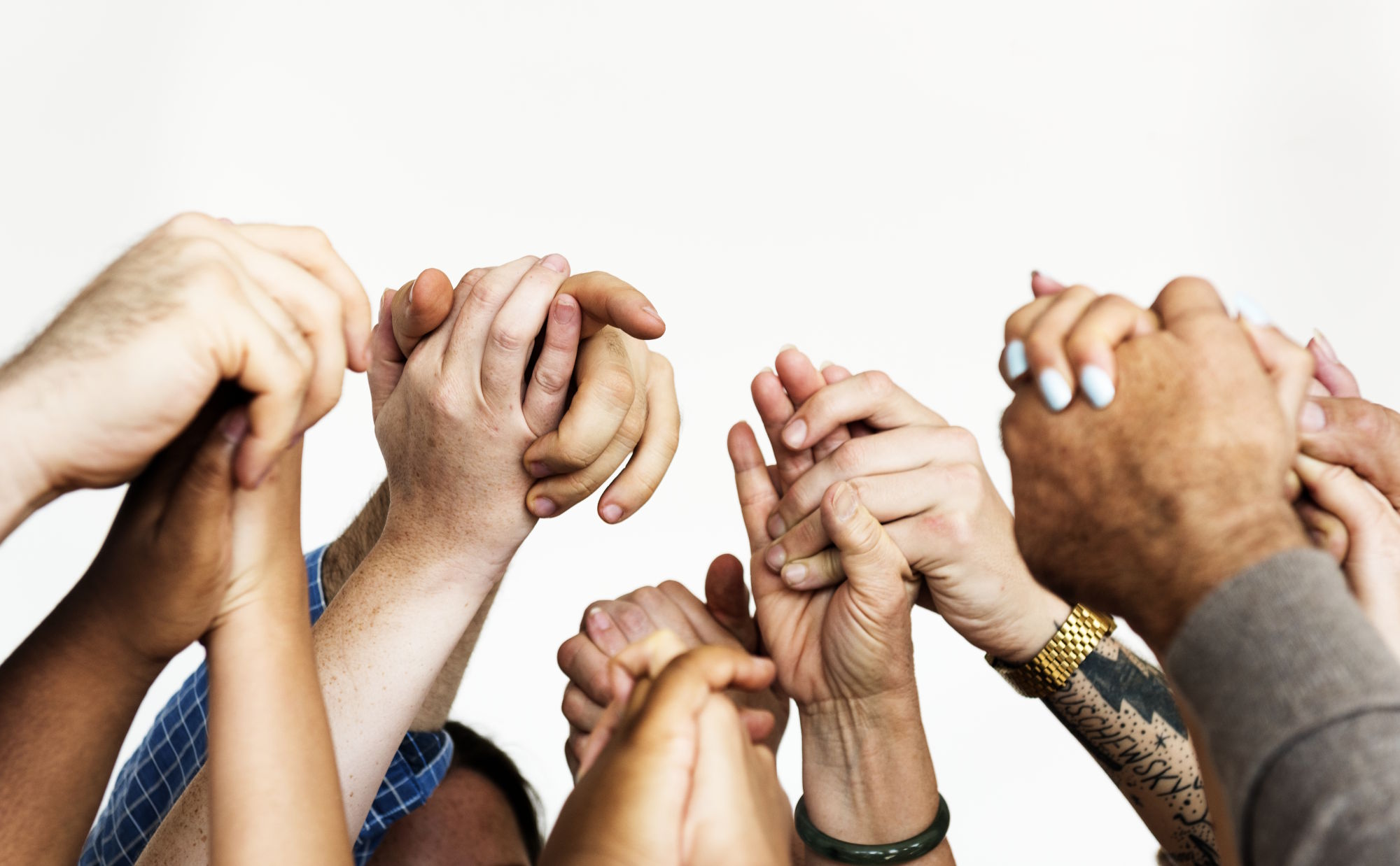 Diverse healthcare team holding hands, representing cultural competency in caregiving