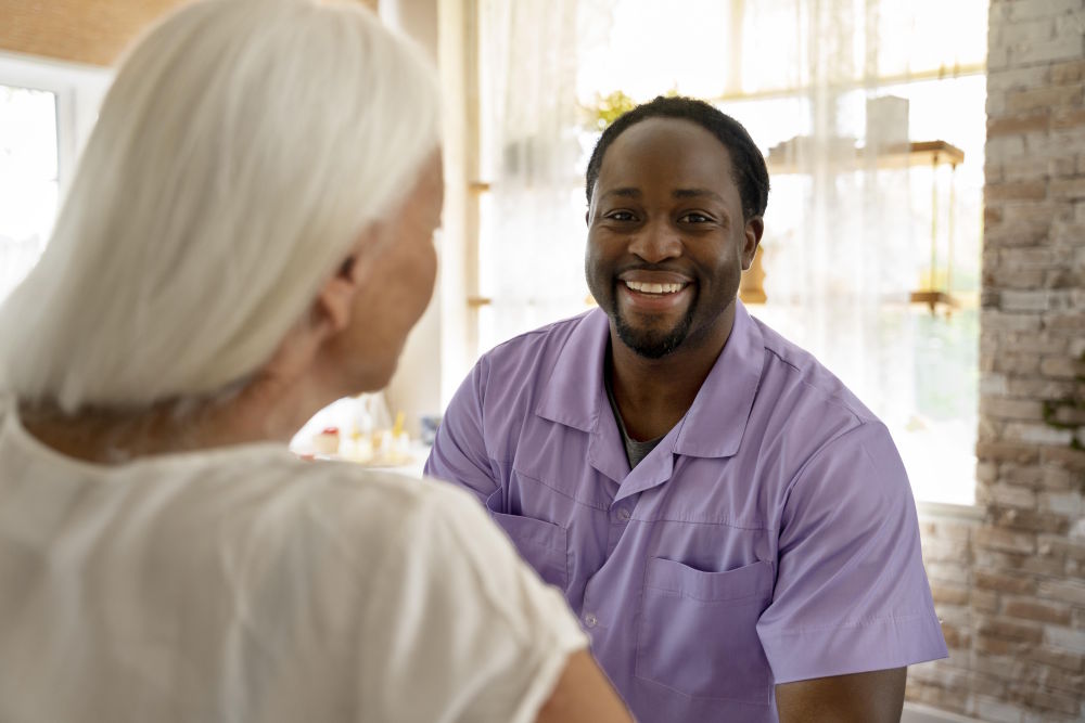 Male social worker providing care to elderly woman